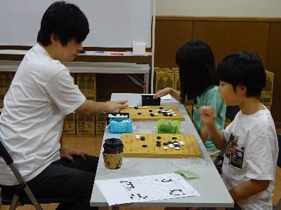 講師と対局をしている子どもたちの写真