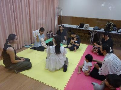 絵本の読み聞かせを聞いている幼児親子たちの写真