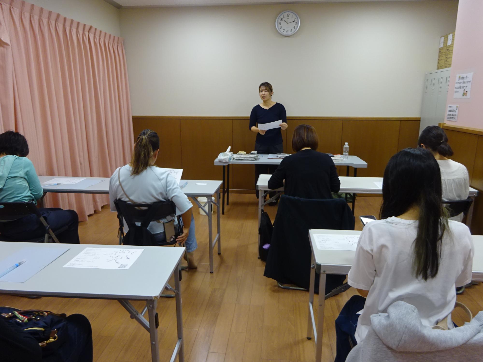 講師の説明を聞いている参加者たちの写真