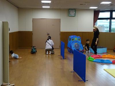 コンビカーや遊具で遊ぶ幼児親子たちの写真
