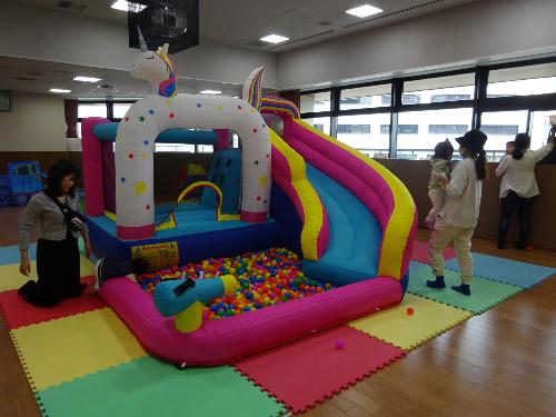 滑り台とボールプールが付いた大型遊具で遊んでいる乳幼児親子の写真