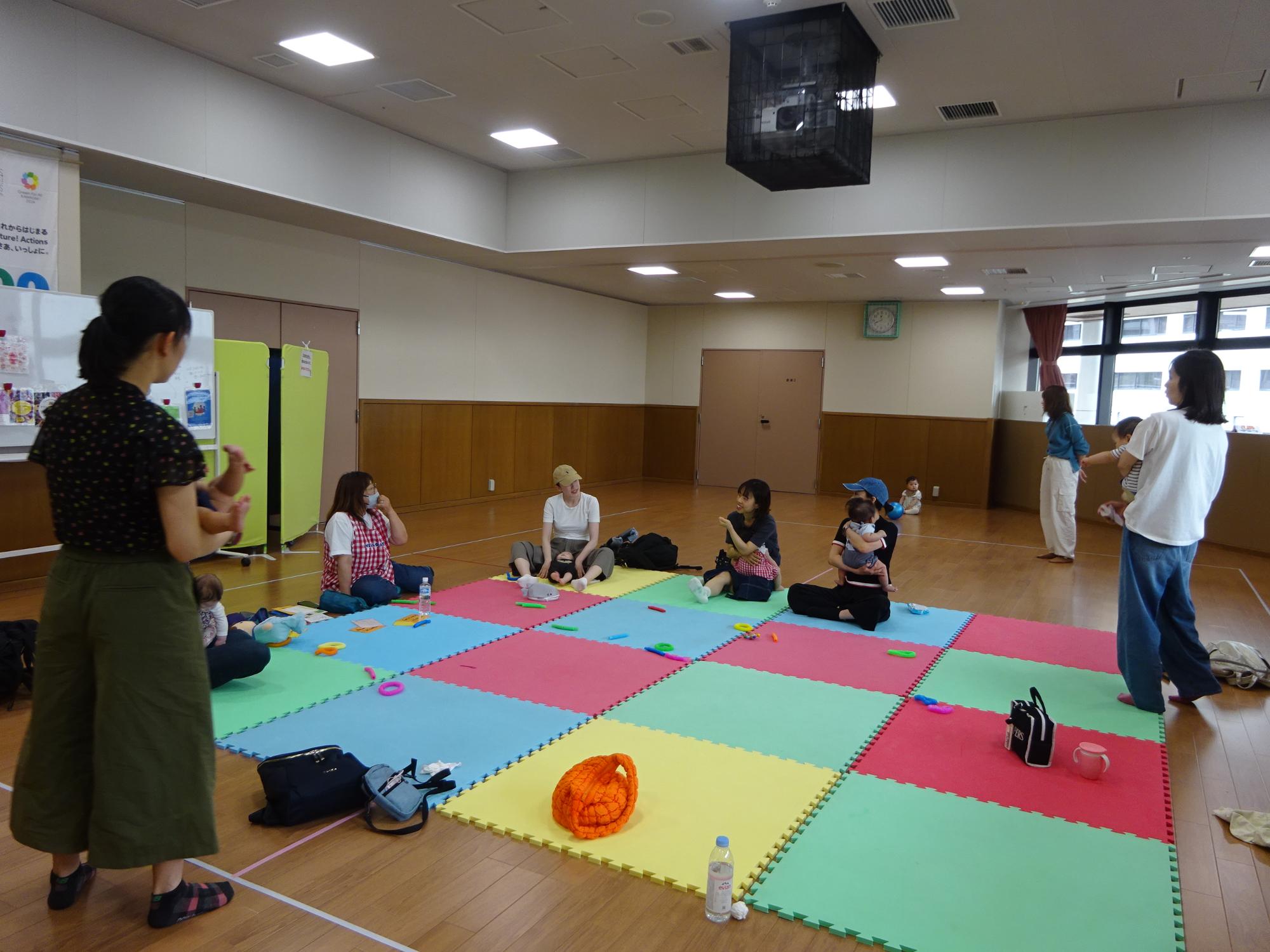 保育士と乳幼児親子たちが話をしている様子の写真