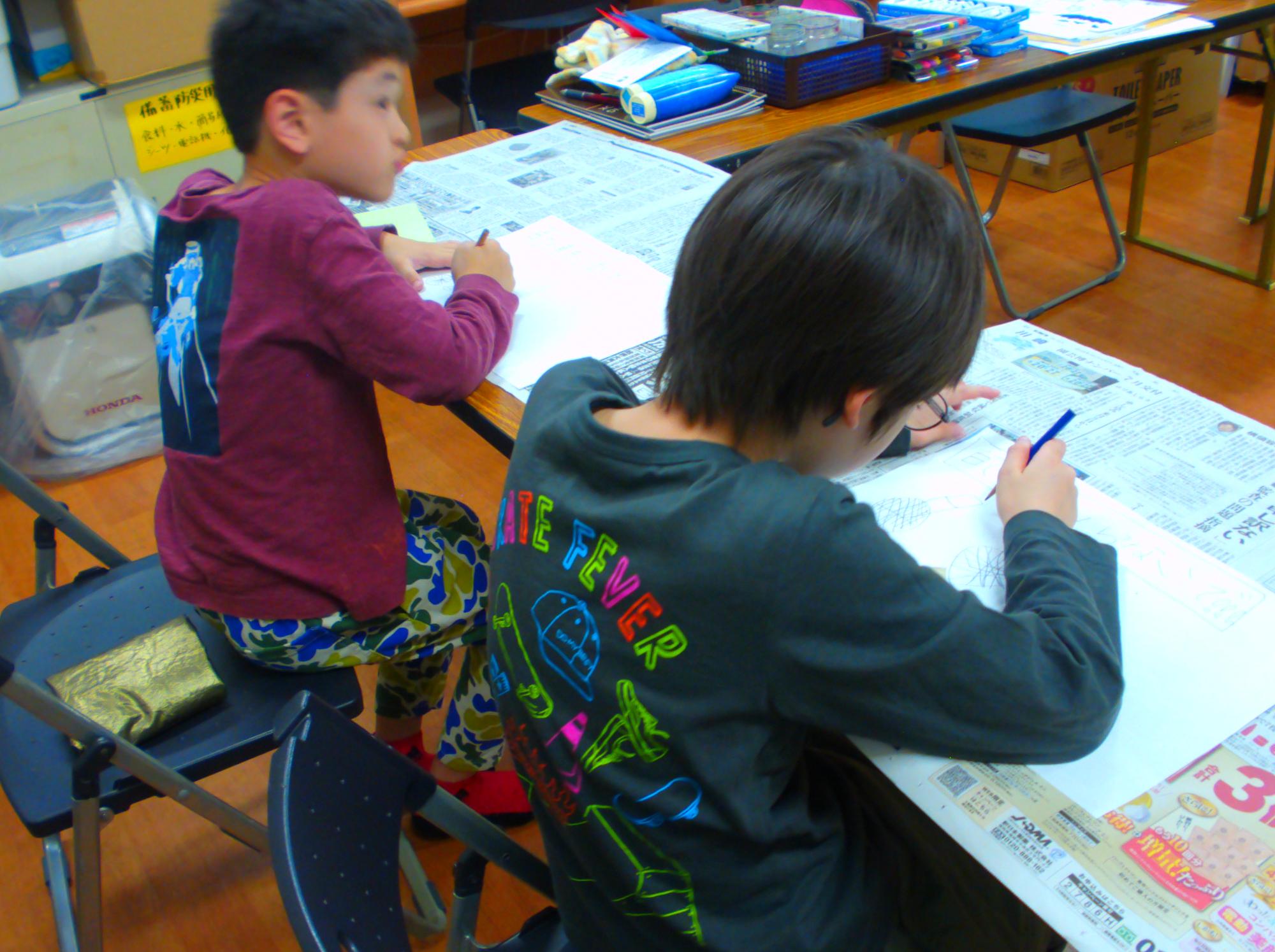 お題の絵を考えながら描いている写真