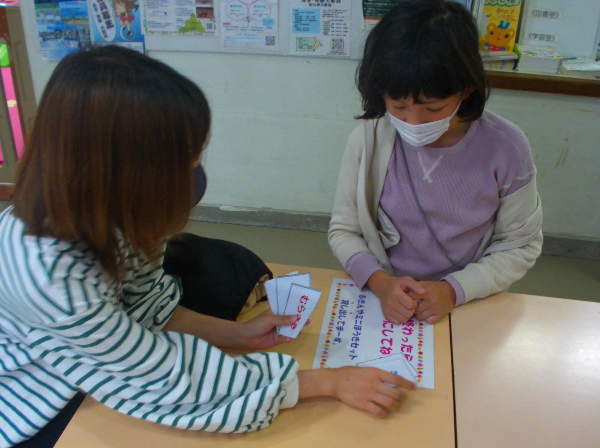 女の子にいろいろもじもじの問題を出している職員の写真