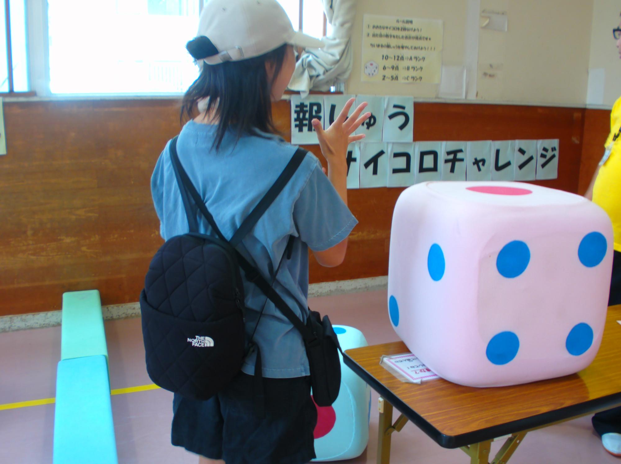 女の子が報酬サイコロチャレンジというゲームをしている写真