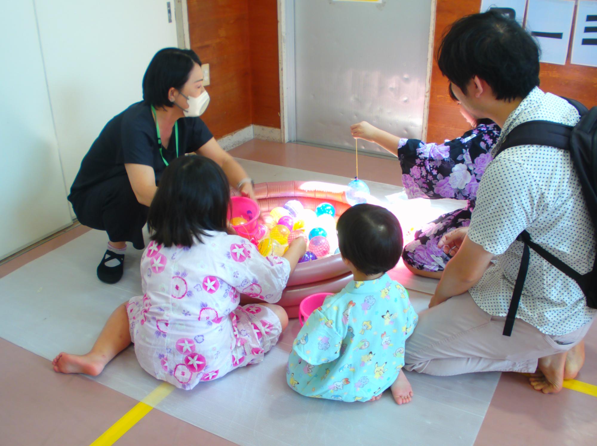 4人がヨーヨーつりをしている写真