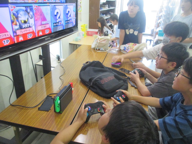大きな画面を囲ってみんなでゲームをしている様子