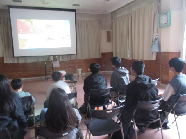 中学生と小学生で譲り合いながらゲームをしている写真