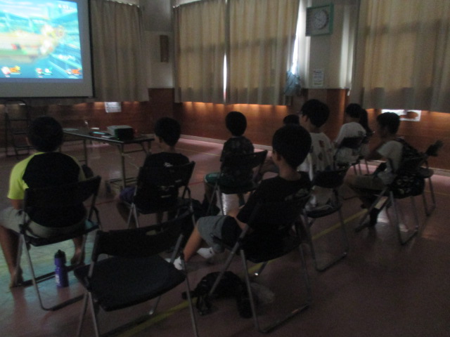 スクリーンを使い大画面でゲームをしている写真