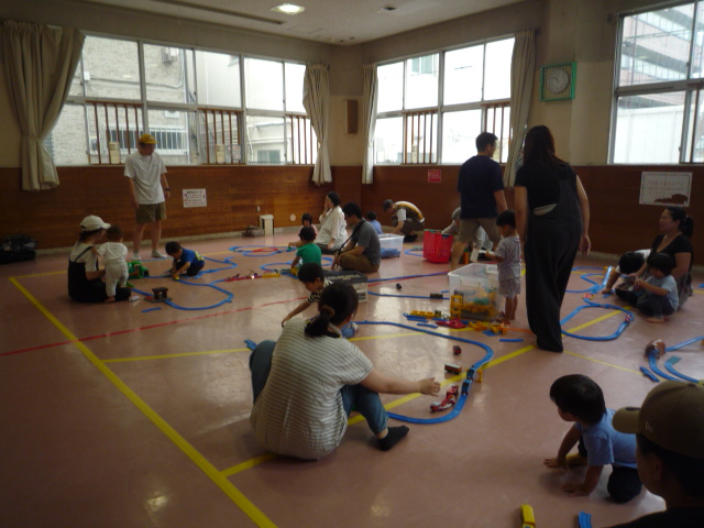 乳幼児親子がプラレールで遊んでいる写真