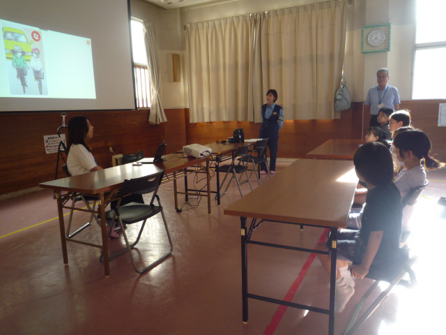 小学生6人が交通安全カルタの読み手当てクイズをしている写真