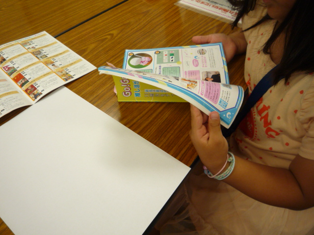 雑誌を見ながら気になる場所を探している小学生の写真