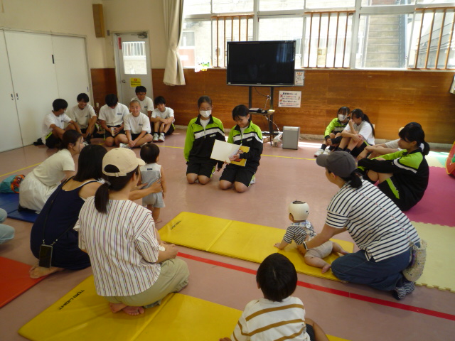 中学生が絵本の読み聞かせや手遊びをしている写真