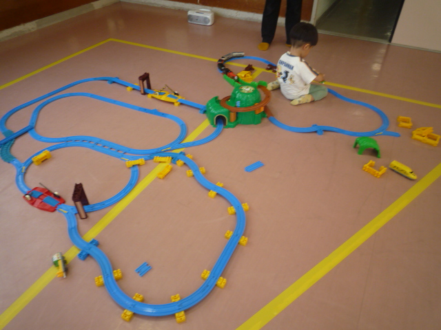 大きい線路で遊んでいる幼児の写真