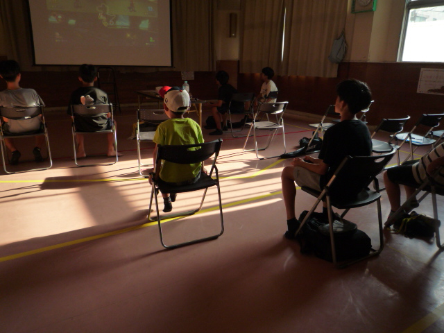 小学生と中学生がマリオカートのゲームで遊んでいる写真