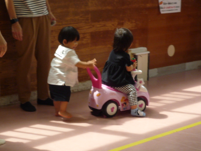 幼児がコンビカーに乗っている幼児を運んでいる写真