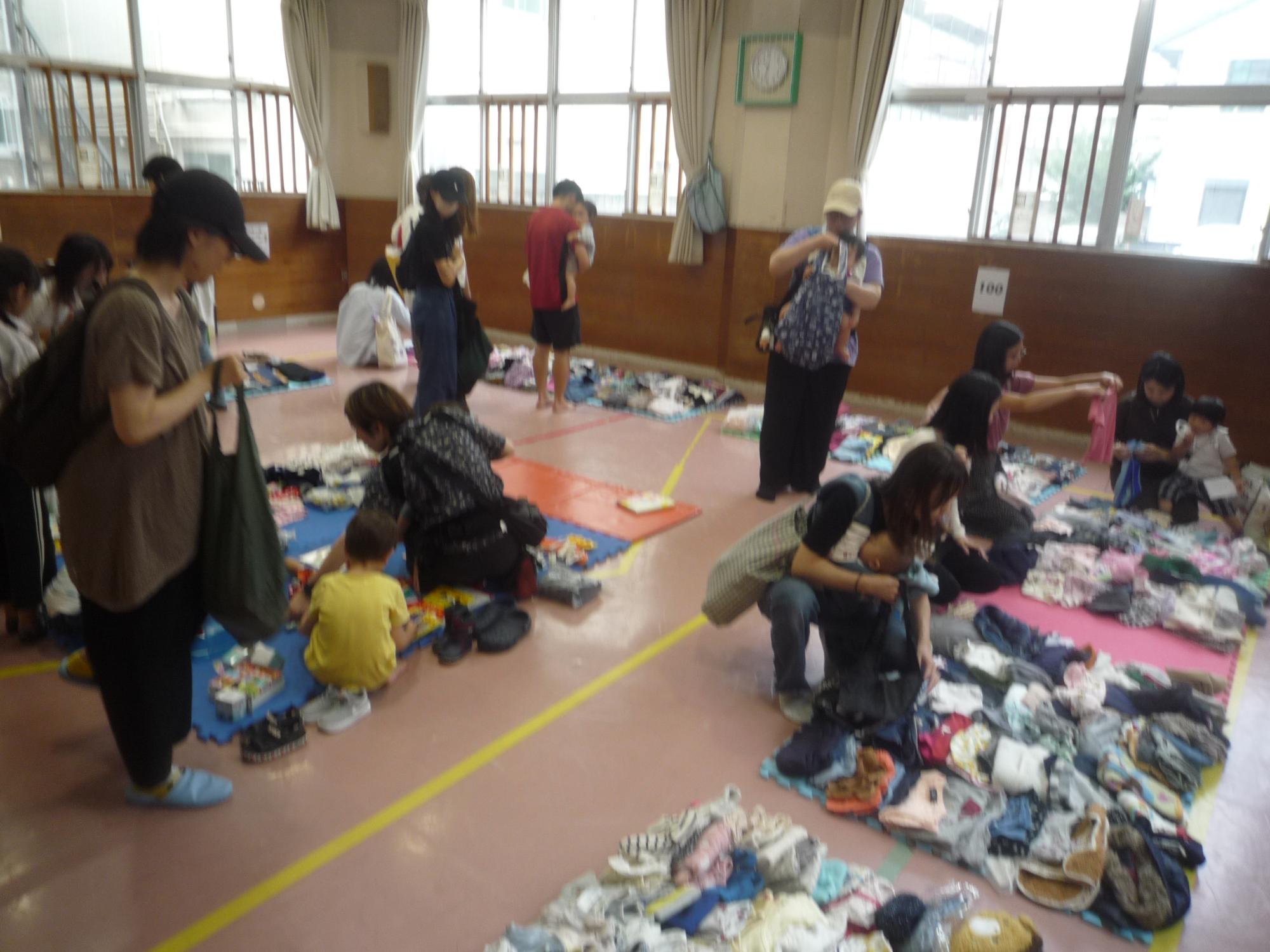 サイズ別に並んでいる洋服を手に取る様子