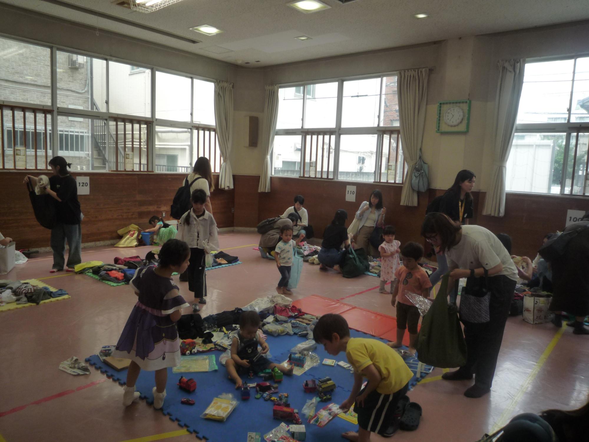 洋服やおもちゃを選ぶ乳幼児親子の様子