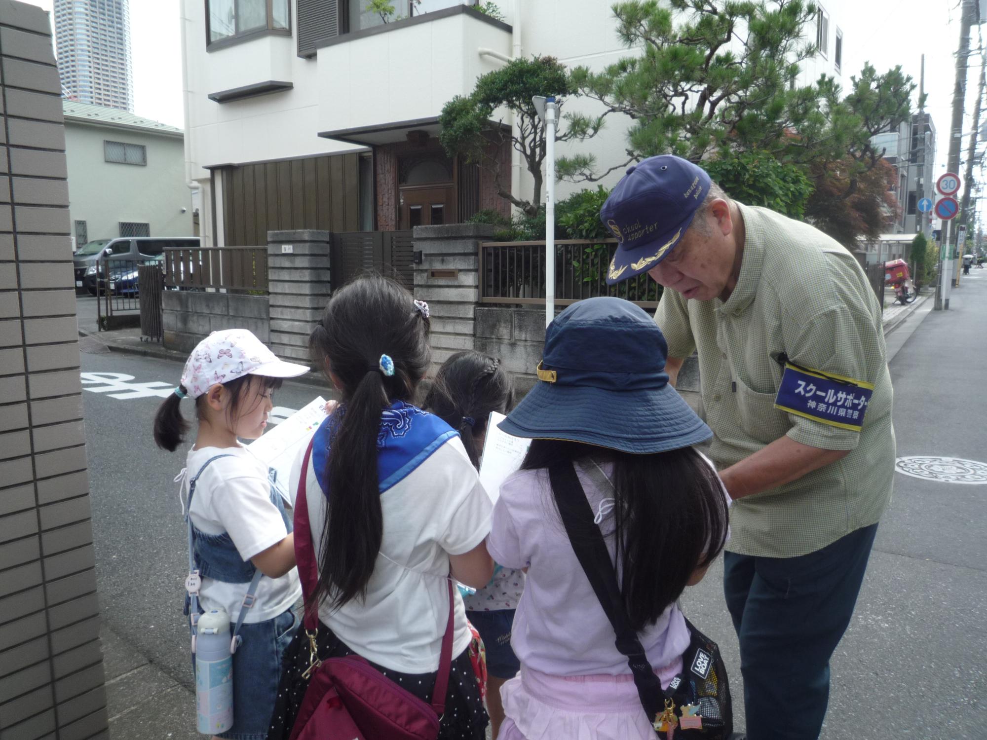 スクールサポーターさんと一緒に地図を確認する小学生