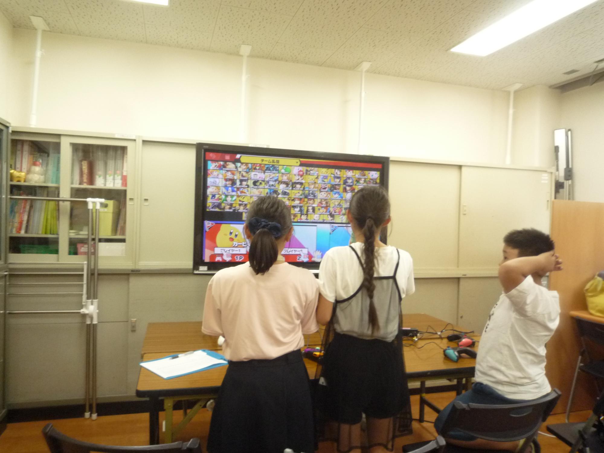 立ち上がって真剣にゲームをする小学生