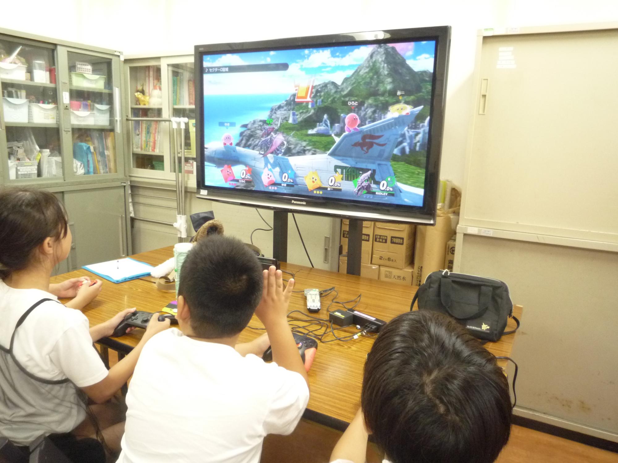 大きな画面でゲームをする小学生たち