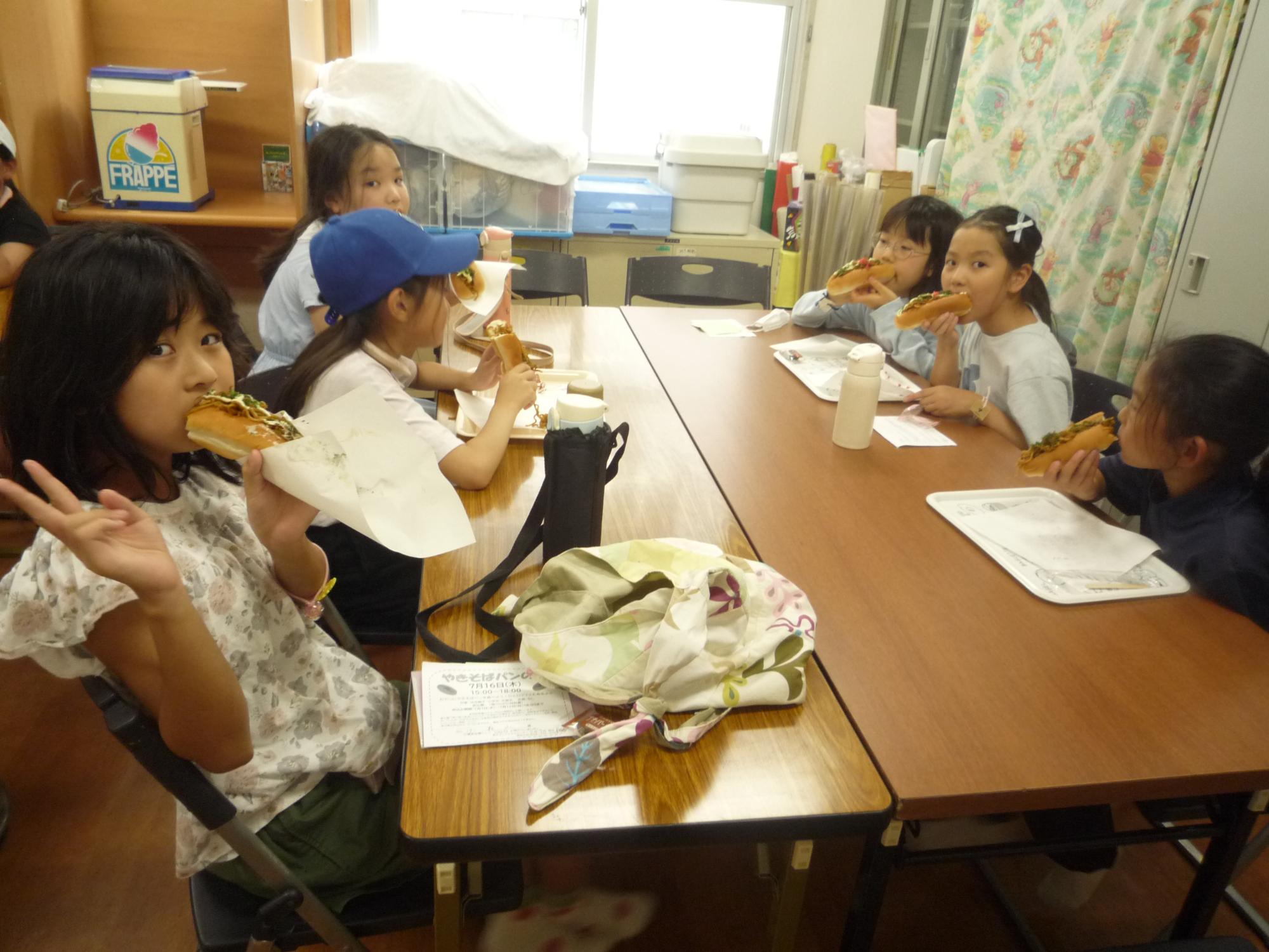 マヨネーズ、青のり、紅ショウガのかかった焼きそばパンを食べる小学生