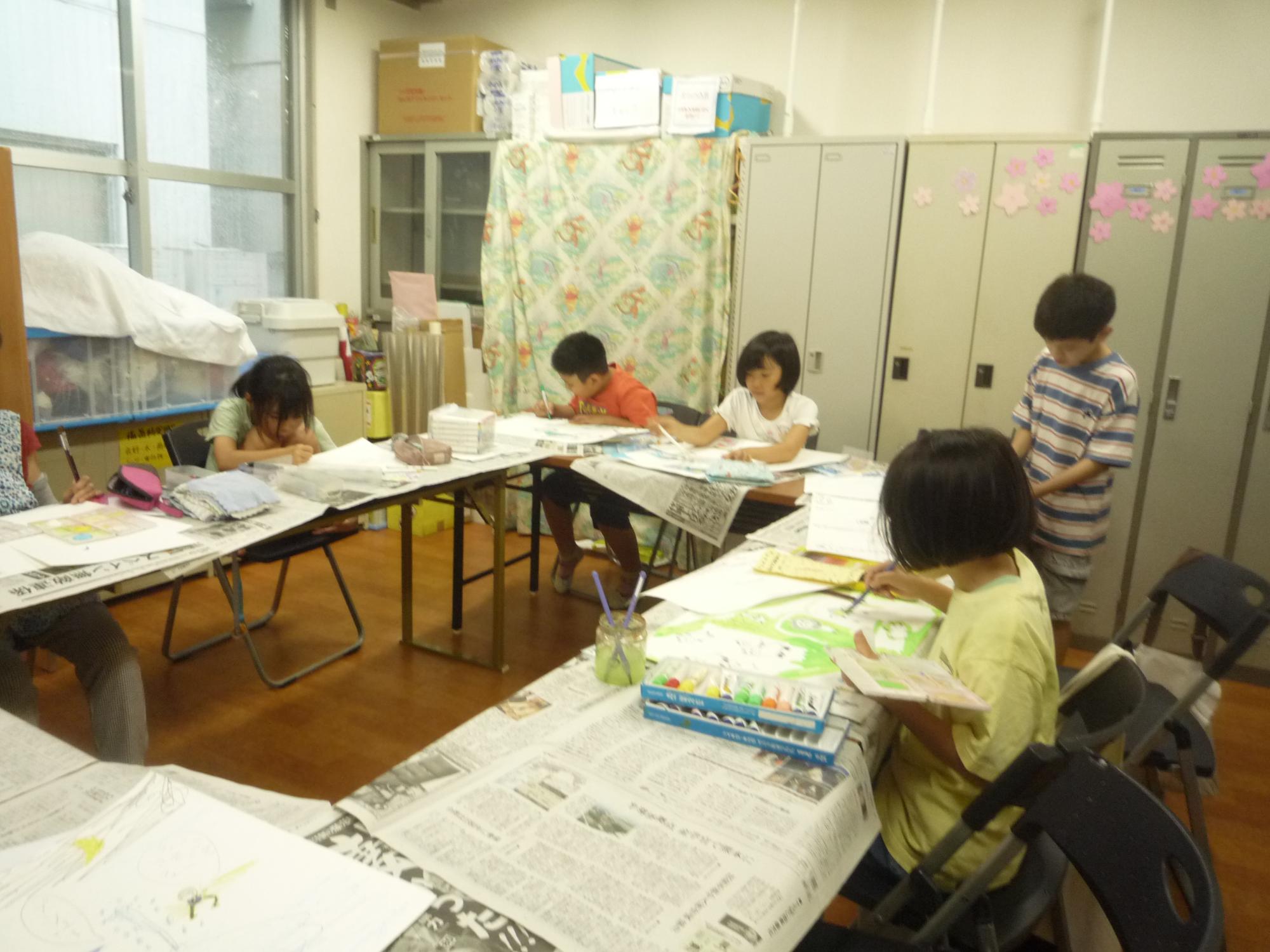 絵具を使って色を塗る小学生