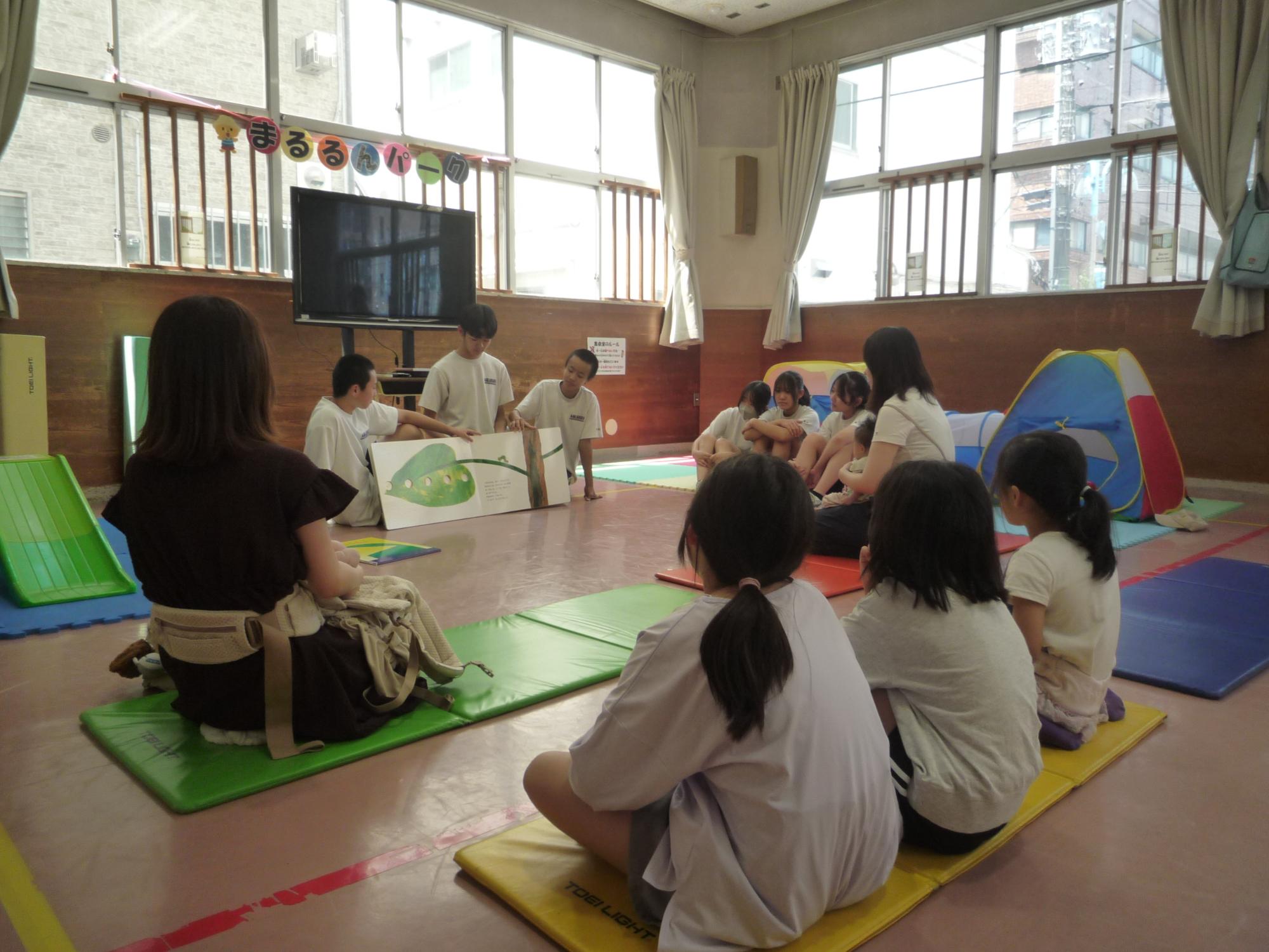 絵本の読み聞かせをする中学生たち