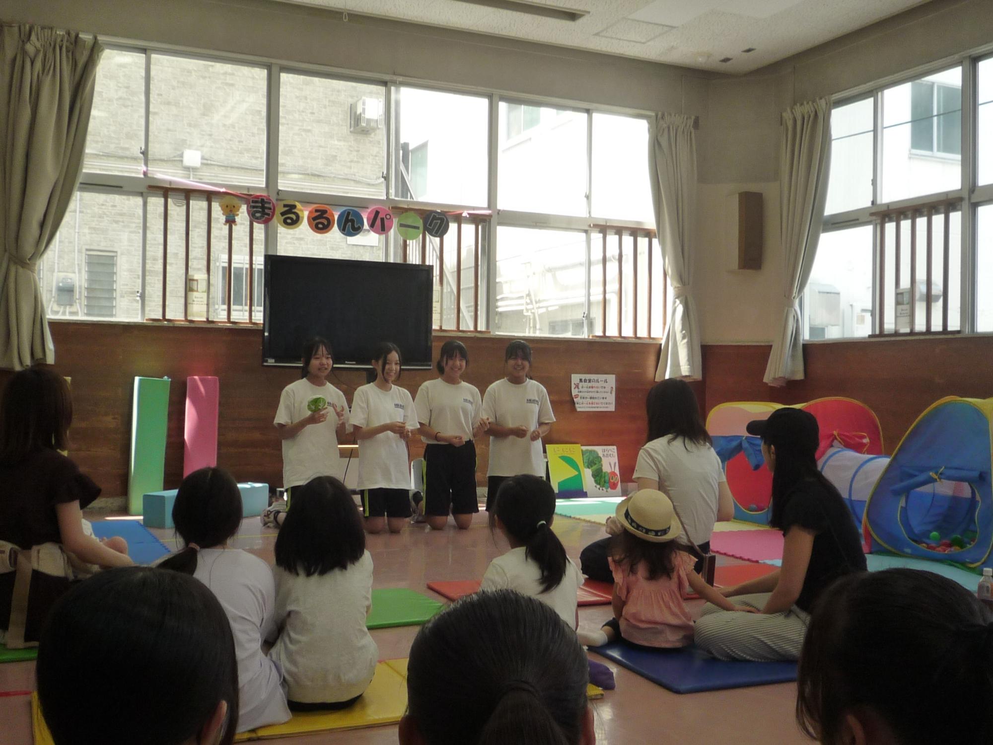 手遊びを乳幼児さんたちに披露する中学生たち