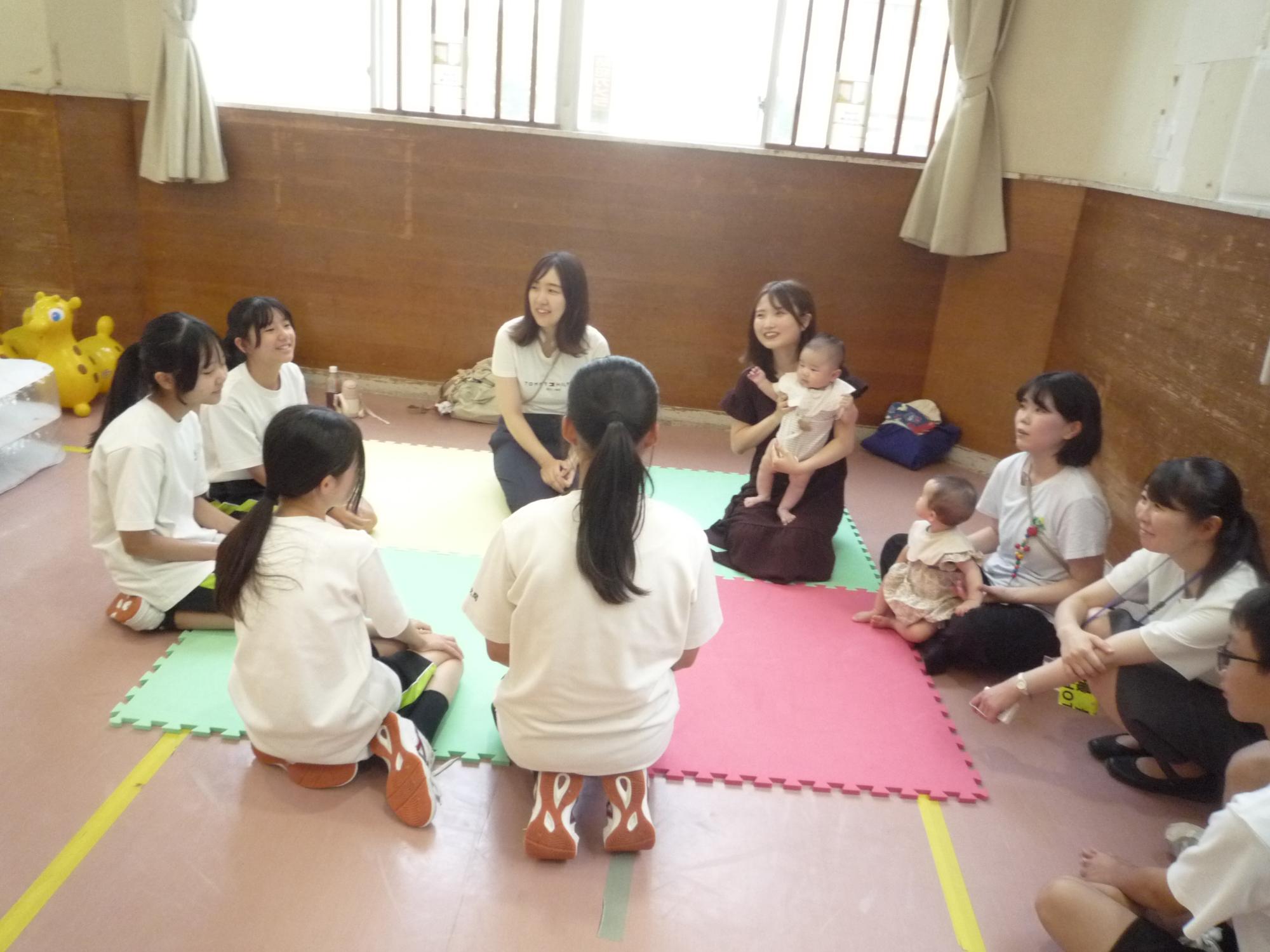 乳児さんのママさんからお話を聞く中学生たち