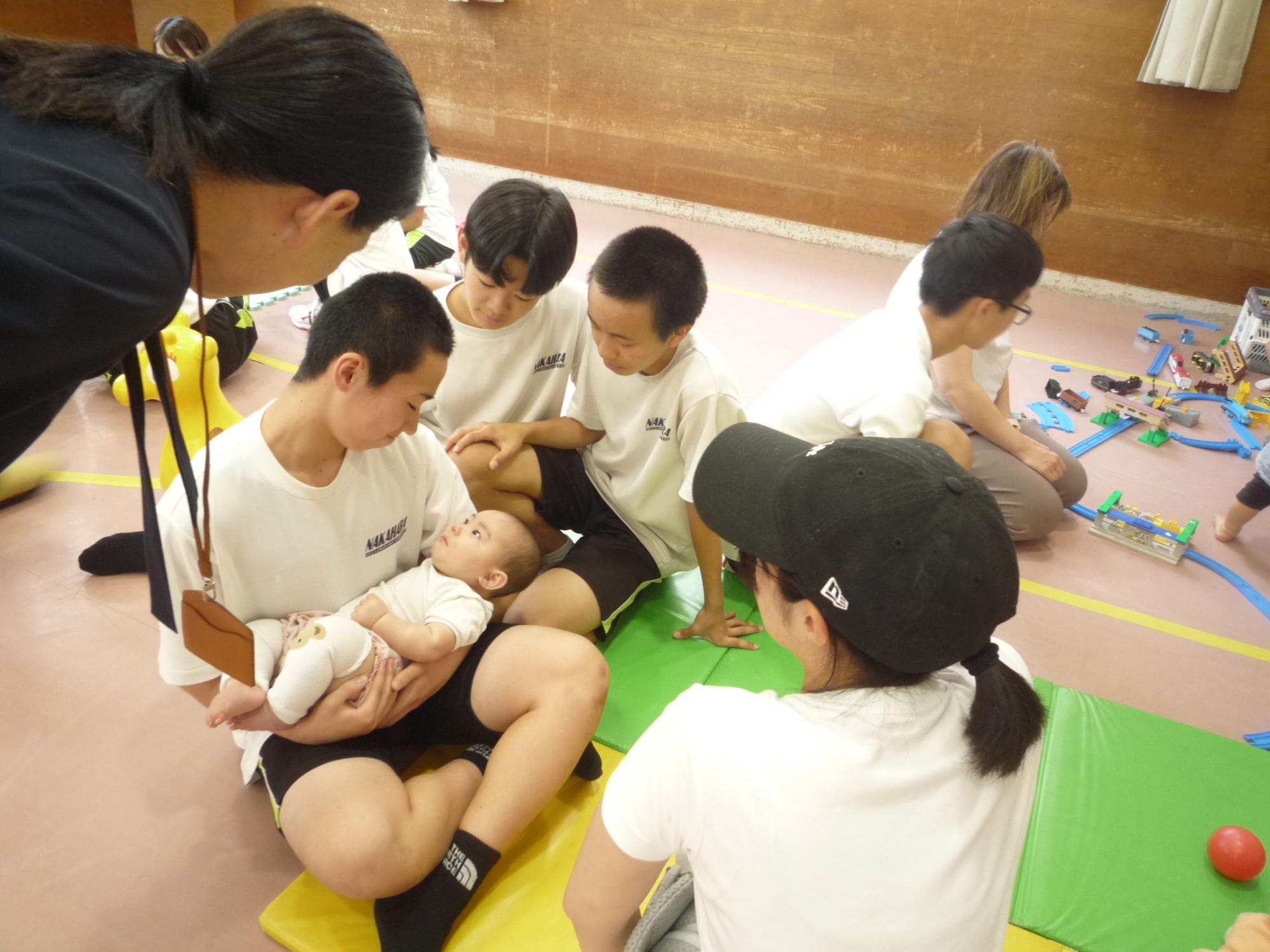 赤ちゃんをだっこする男子中学生