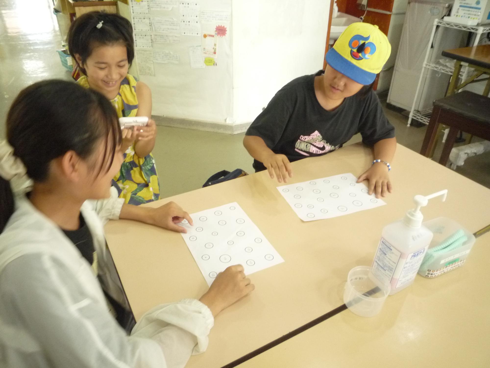 ストップウォッチで時間を計りながらゲームを楽しむ小学生たち