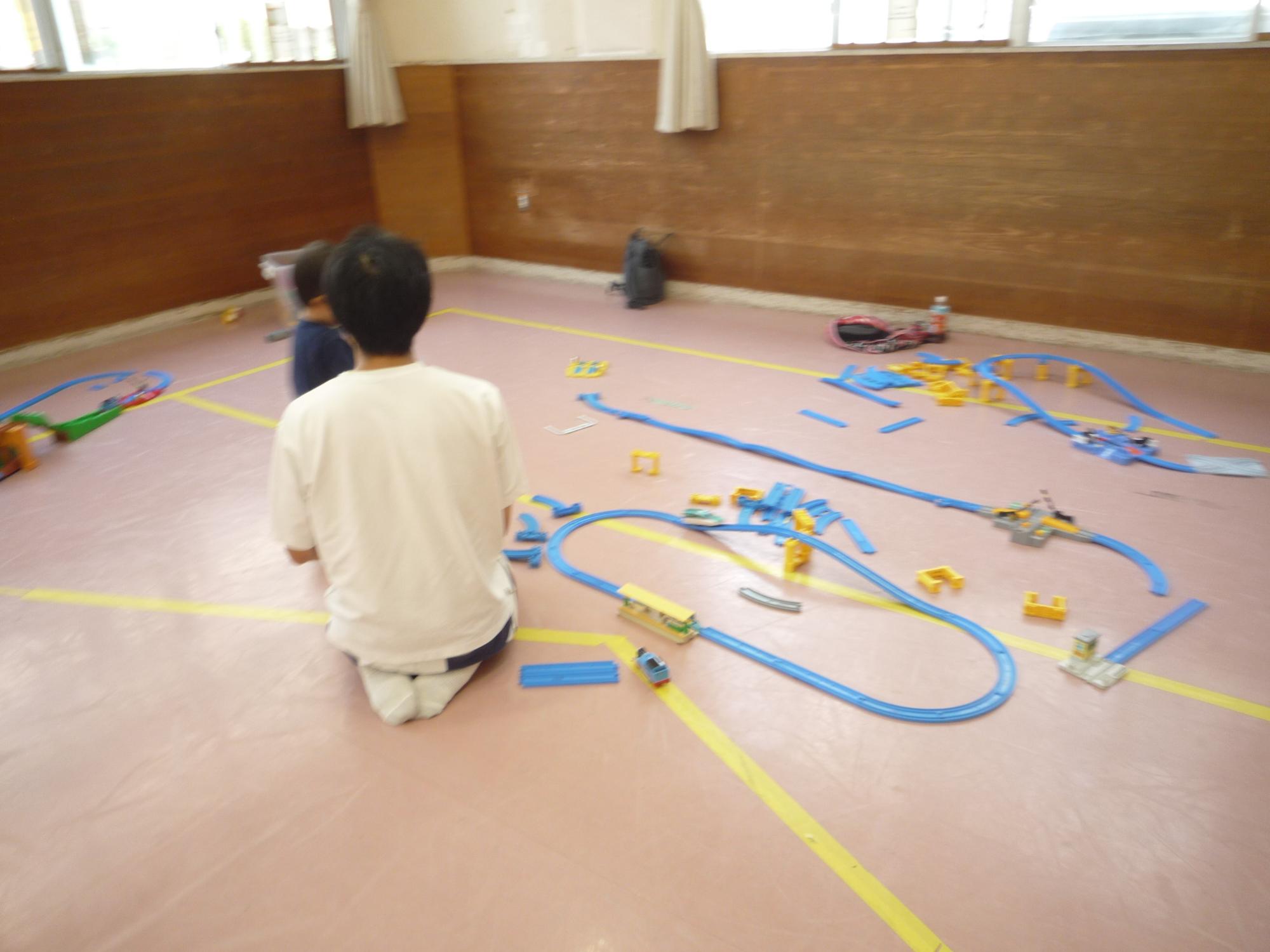 プラレールを作る子どもを見守る大人