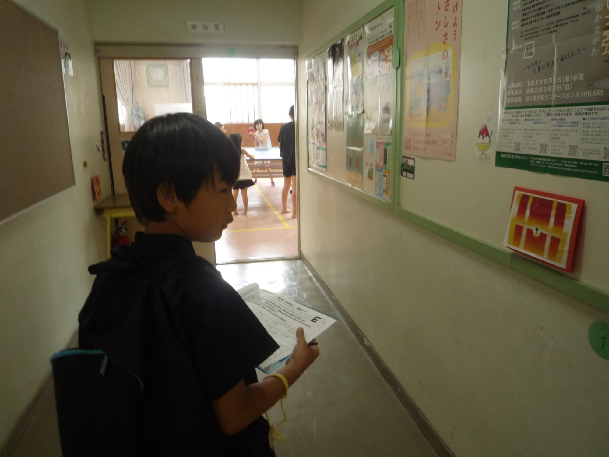 宝箱ヒントの前に立つ小学生