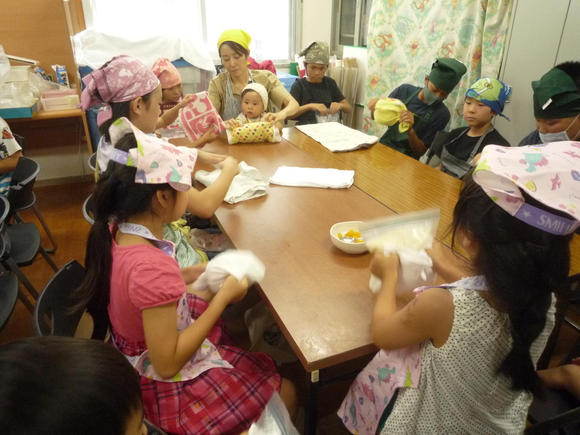 材料の入ったジップロックをふりふりする子どもたち