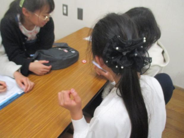 女の子三人でコイントスをしている写真