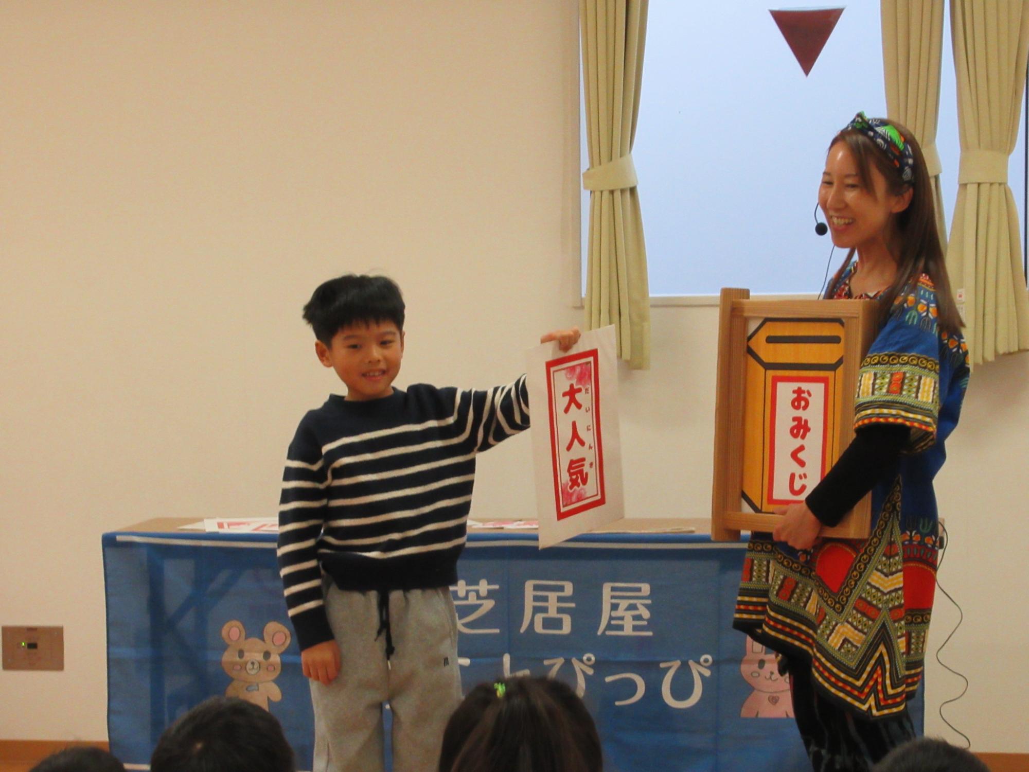 おみくじで大人気を引いた子どもの写真