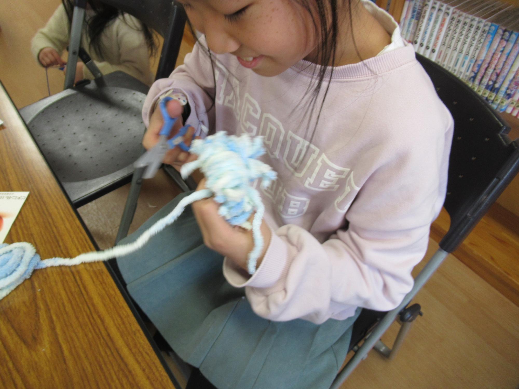 けん玉のポンポンを作っている子どもたちの写真