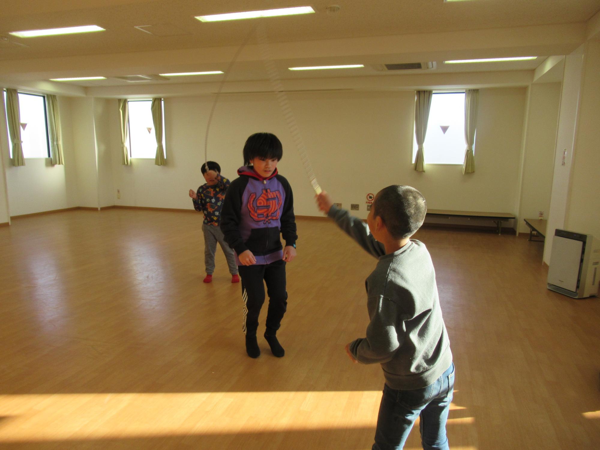 大縄をして遊んでいる子どもの写真