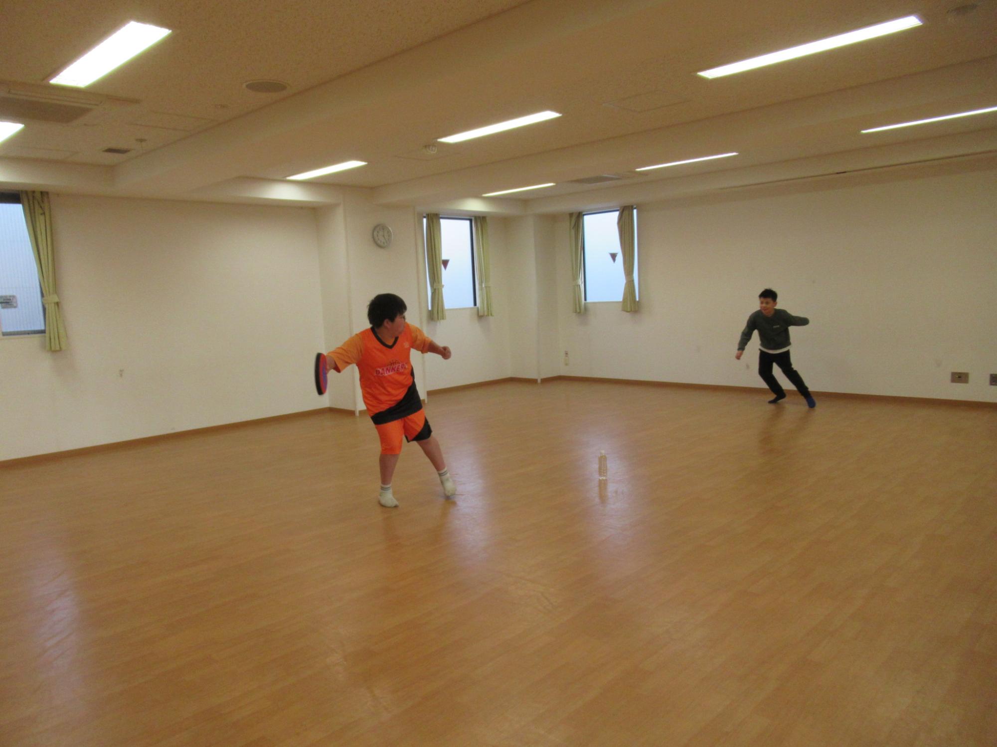 お友達とフリスビーしている子どもの写真