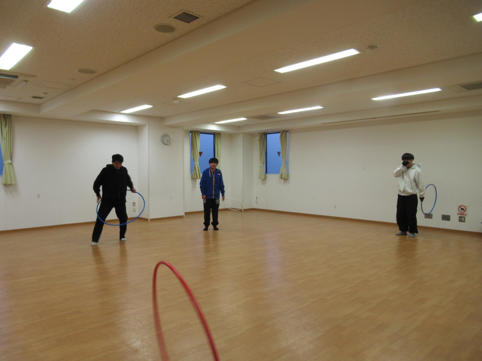 中学生がフラフープで仲良く遊んでいる写真