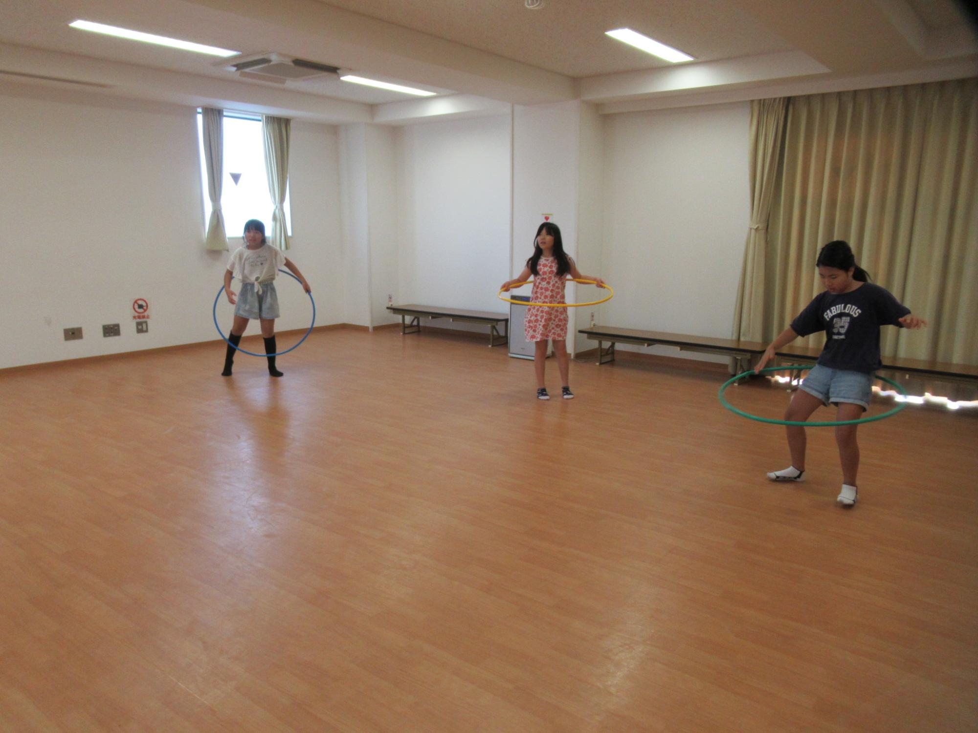 集会室でフラフープをしている写真