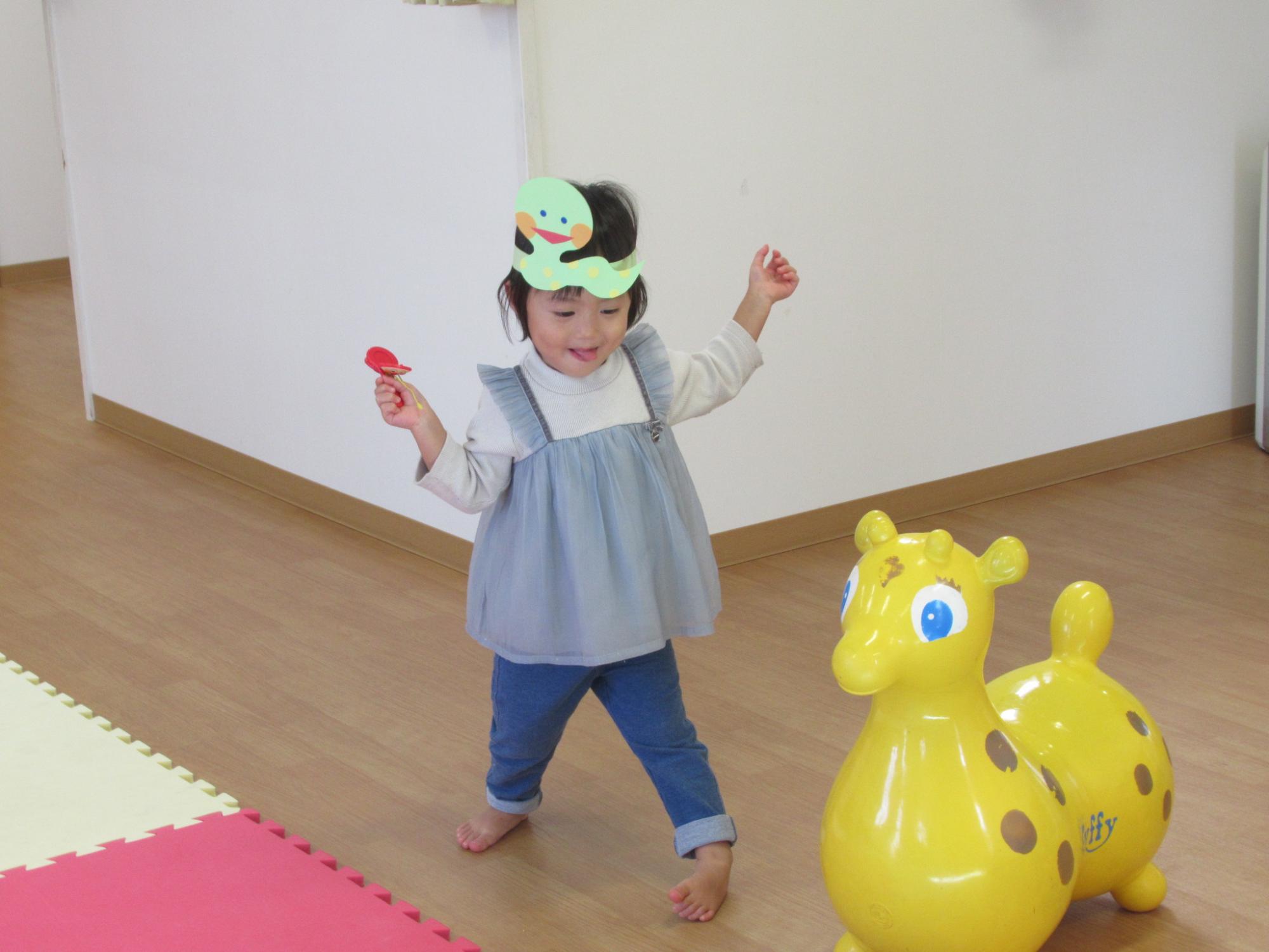 巳年のお面を被って踊る子どもの写真
