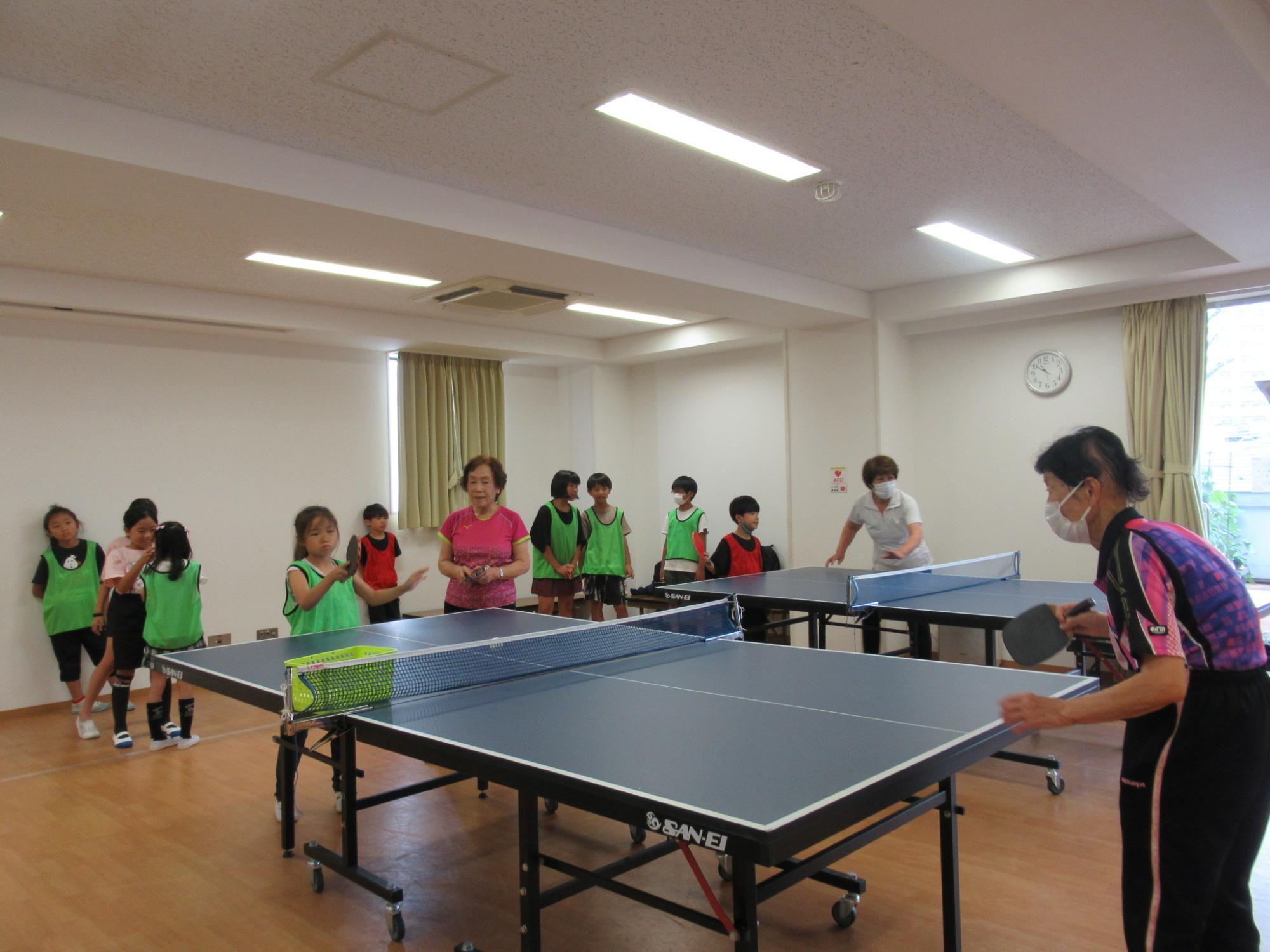 子どもと大人で卓球のラリーをしている様子の写真