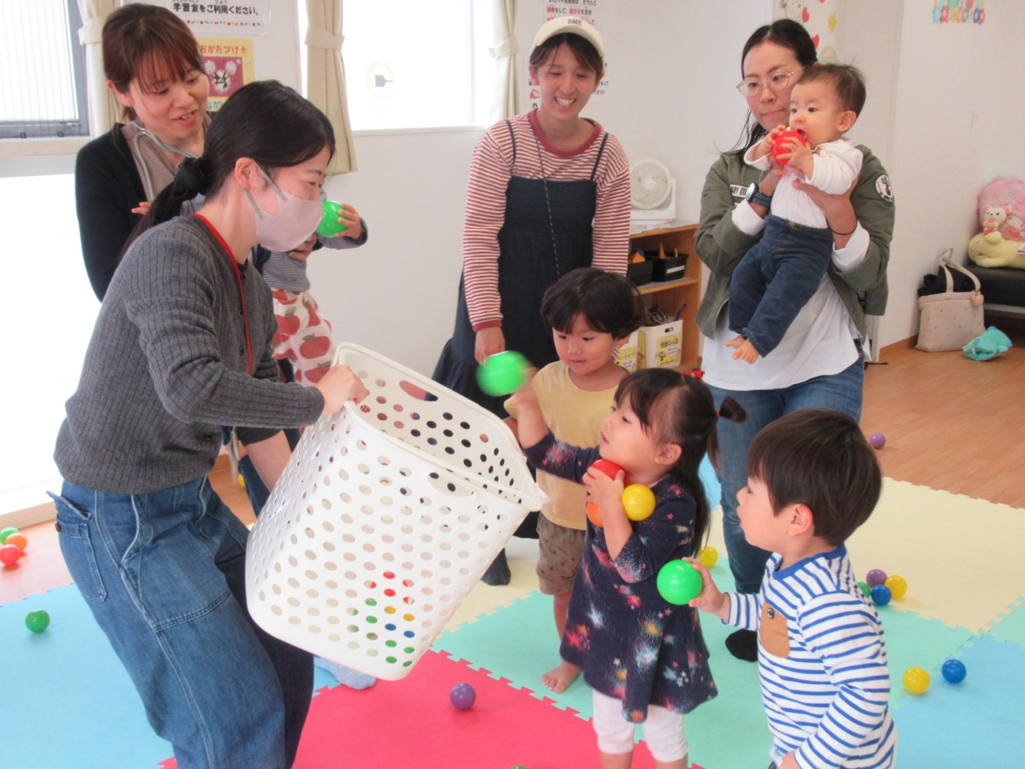 楽しそうに玉入れする幼児親子の写真