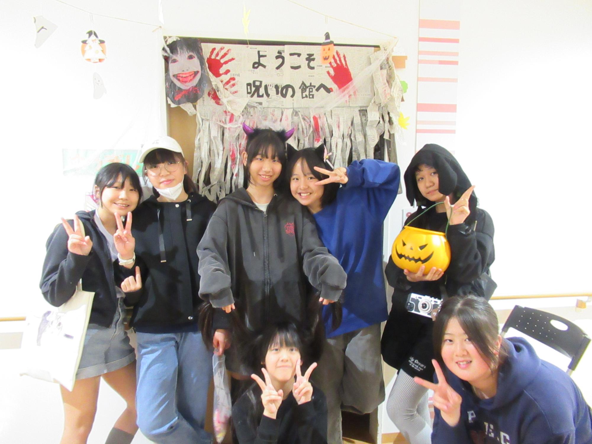 おばけやしきの前でピースする実行委員の写真