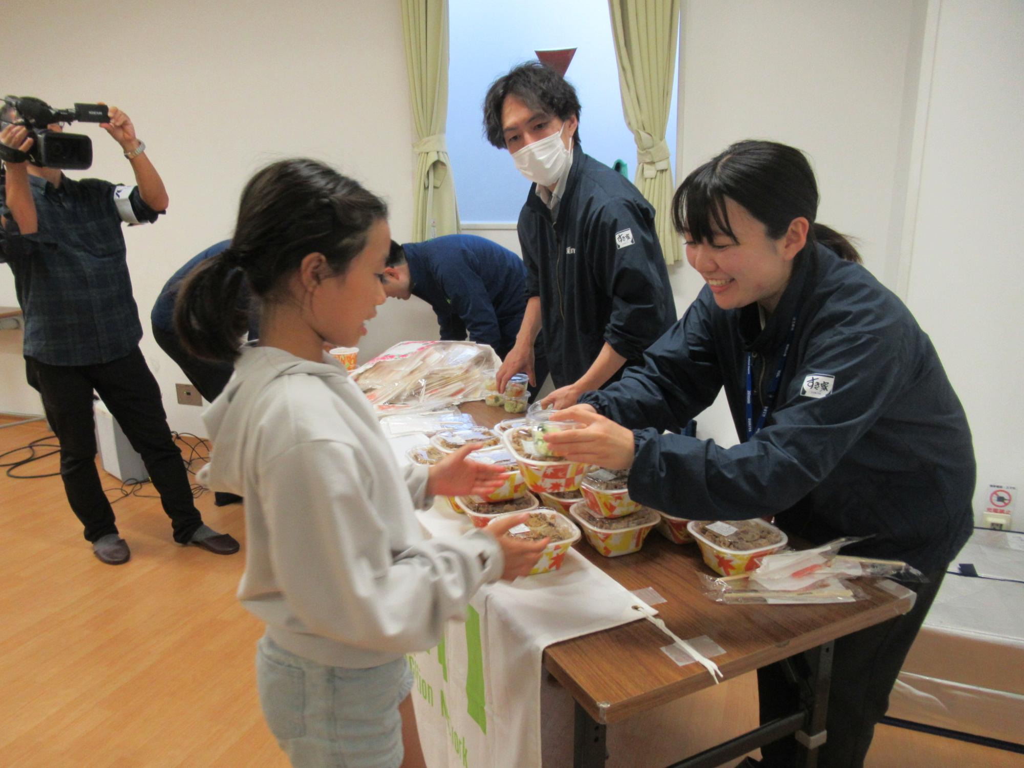 すき家の牛丼を受け取り笑顔の子どもたちの写真