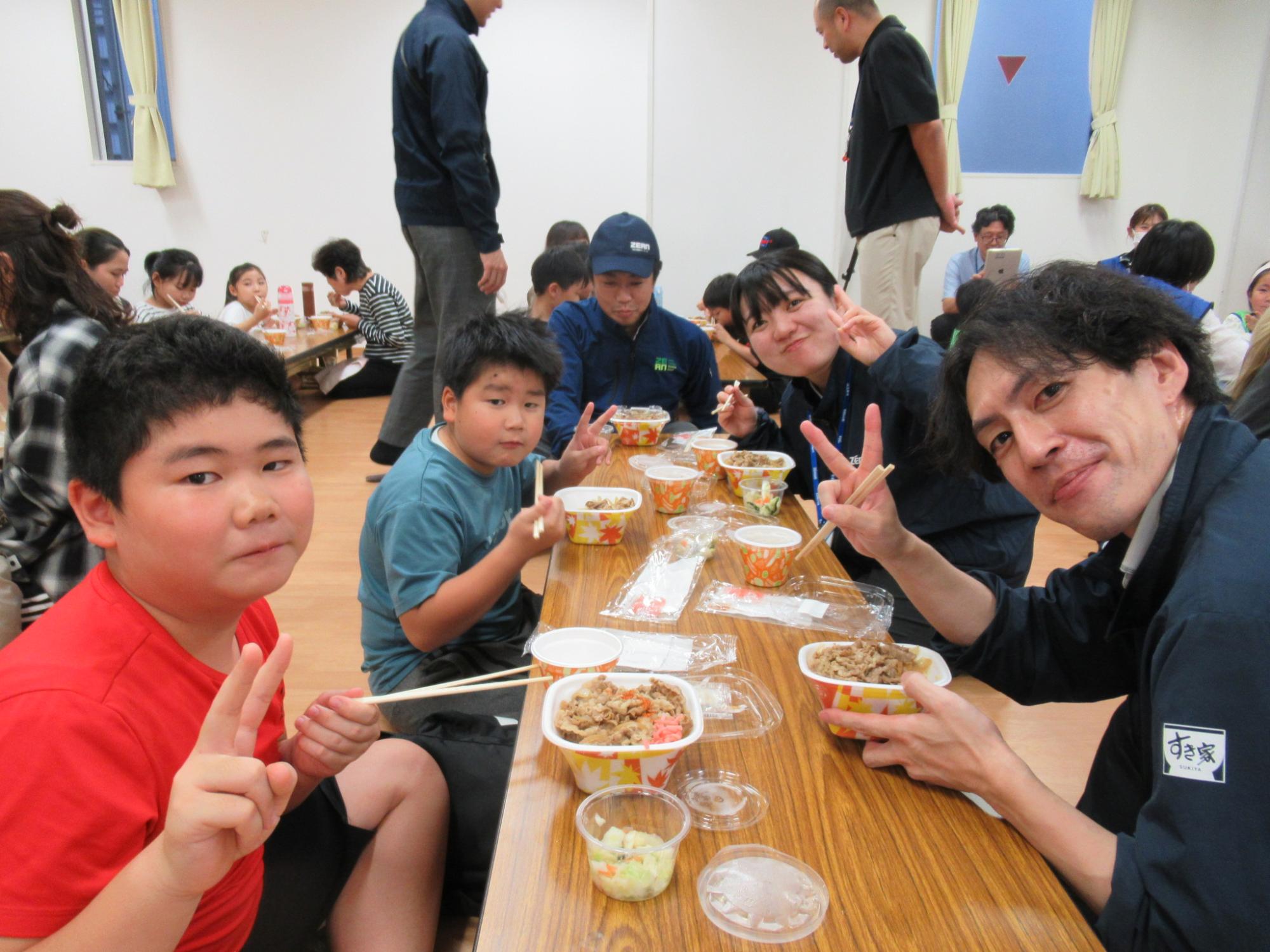 すき家の牛丼を食べてピースをしている様子の写真