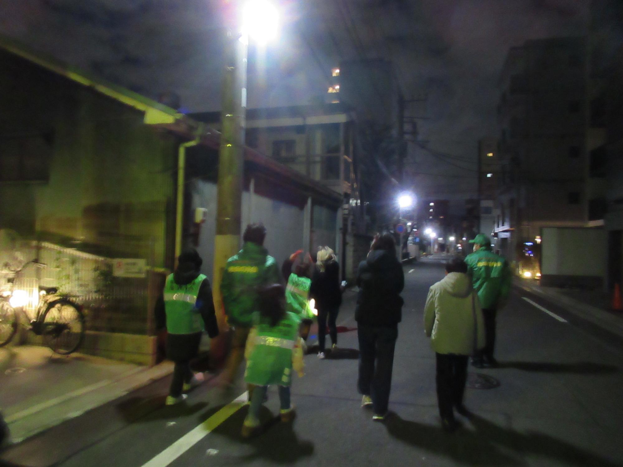 拍子木を鳴らしながら火の用心を地域へ呼びかける子どもたちと成人の写真