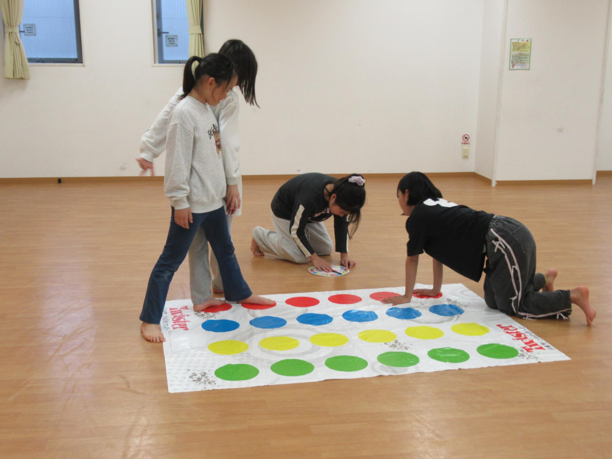 ツイスターを楽しんでいる小学生の写真
